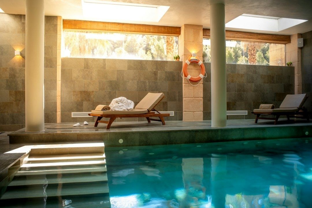 Indoor spa pool with loungers, skylights, and a mounted life ring